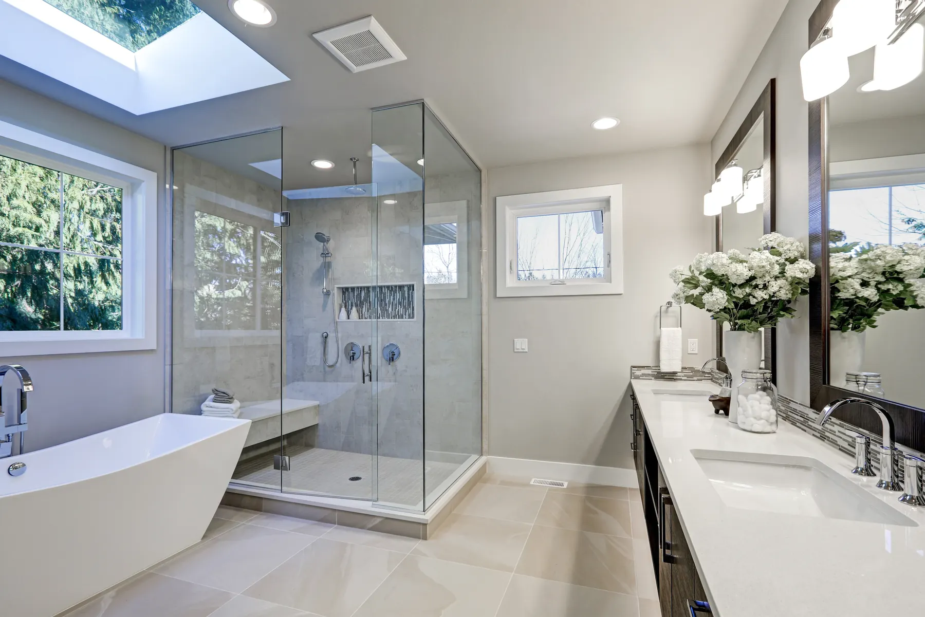 Modern bathroom with a glass shower, a freestanding tub and a double vanity