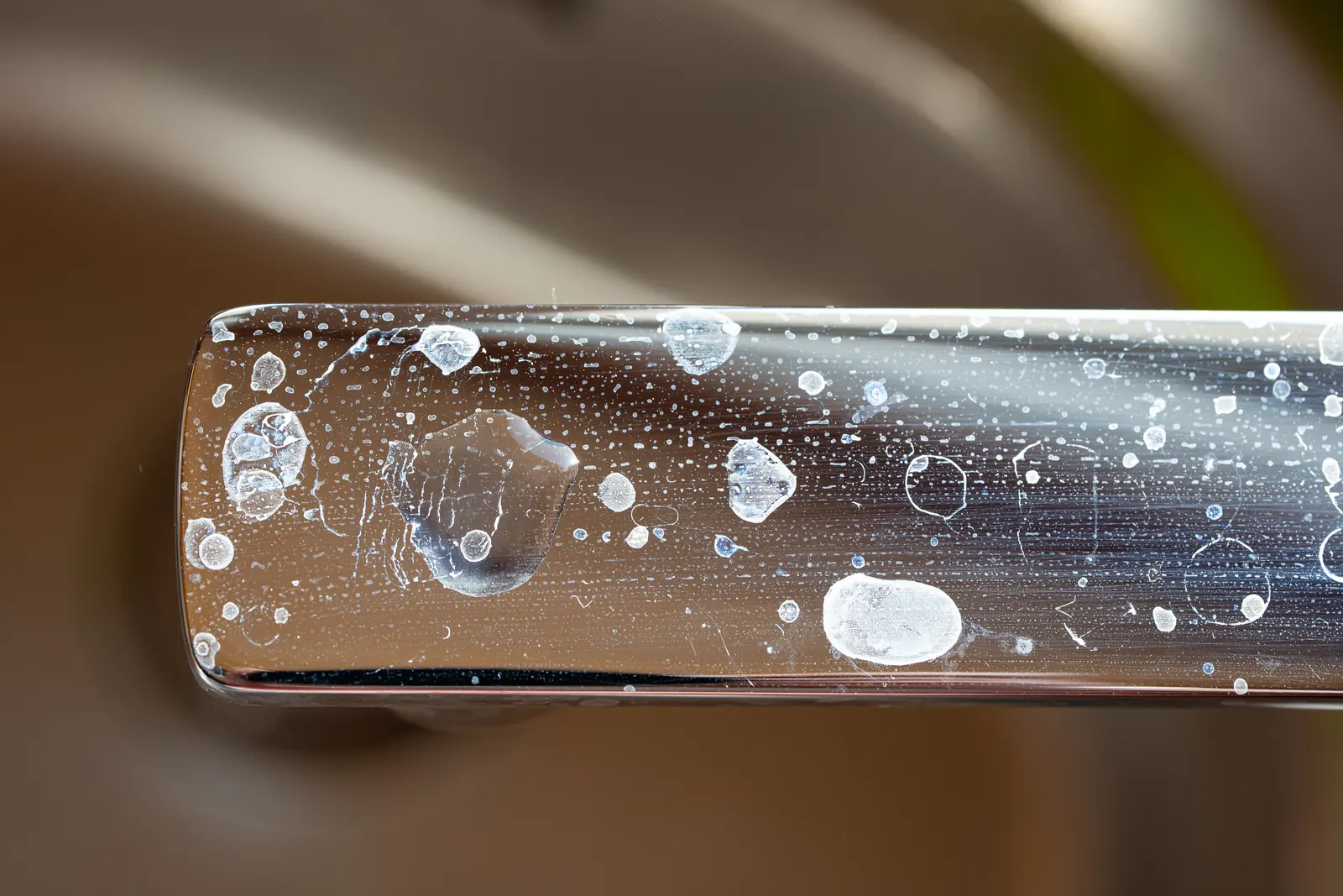 Close-up of mineral spots on a chrome tap